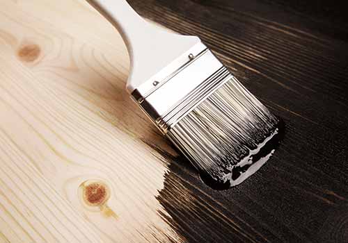 paint brush applying stain to wood